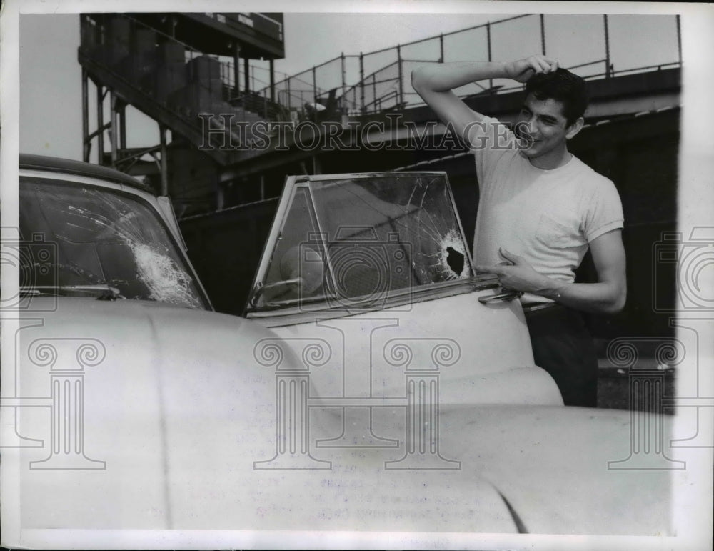1956 Press Photo Paul Garcia looks at two broken windows of his car - Historic Images