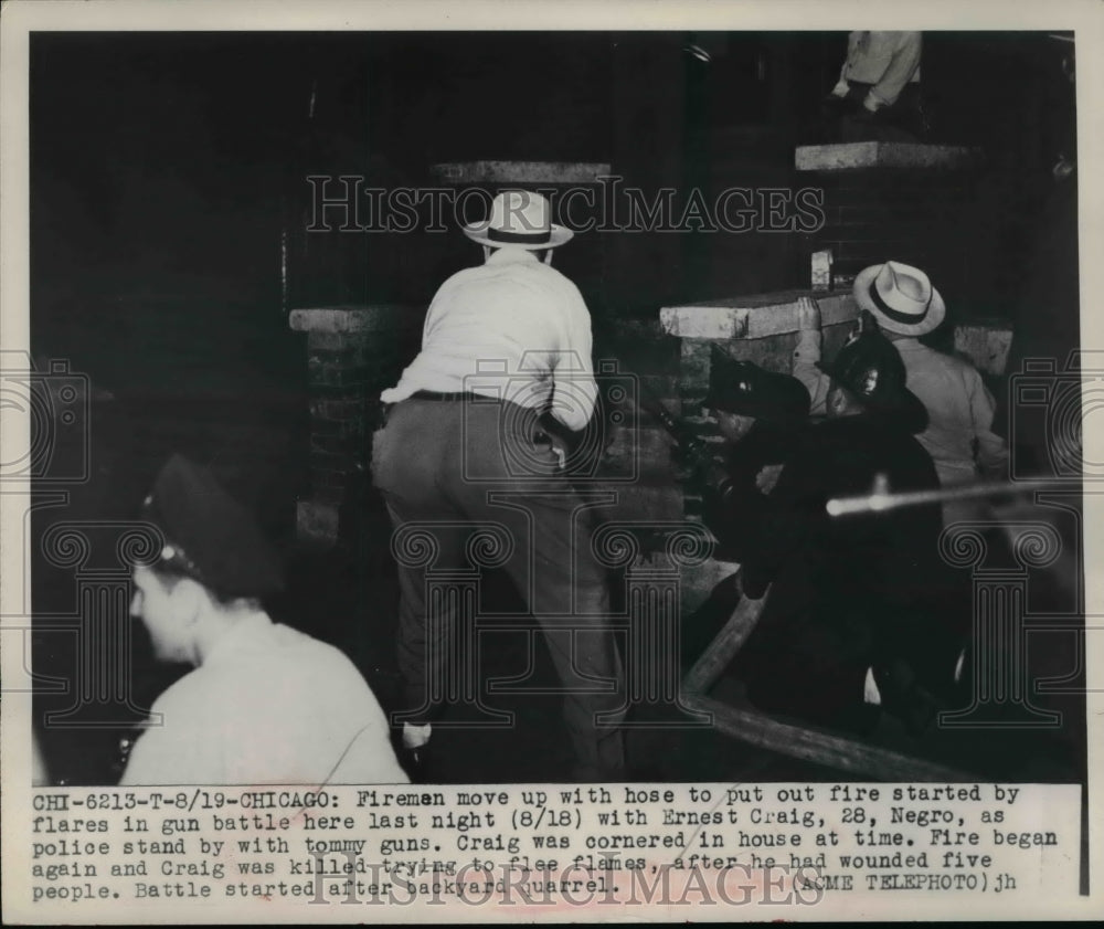 1949 Press Photo Fireman put out fire started by flares in gun battle E. Craig - Historic Images