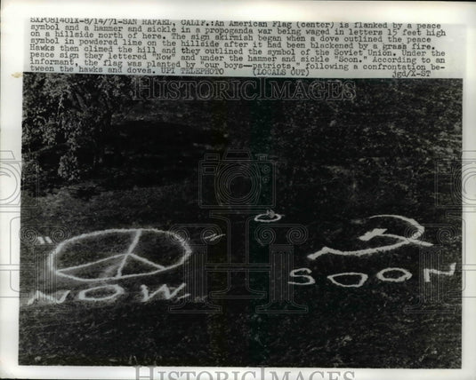 1971 Press Photo "Now" Peace Symbol & "Soon" Hammer / Sickle Hillside Signs - Historic Images