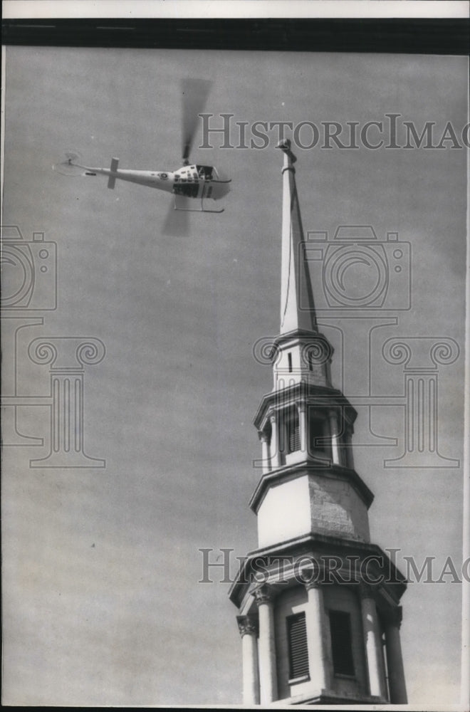 1957 Press Photo A helicopter snare the rope left hanging from a church steeple - Historic Images