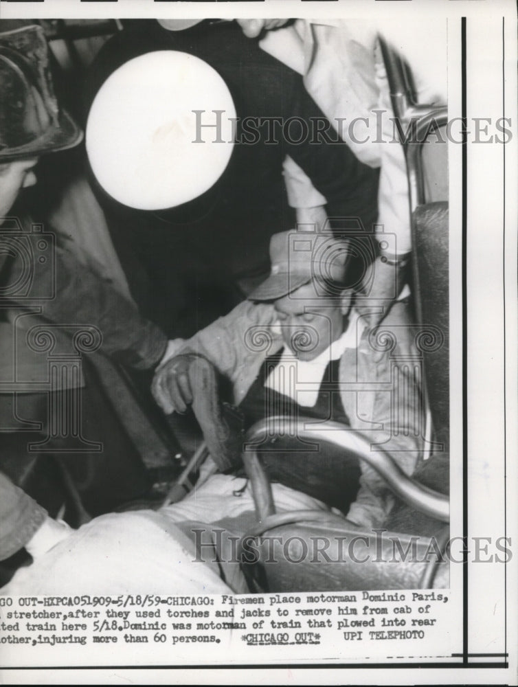 1959 Press Photo Fireman place Dominic Paris in stretcher after remove from cab - Historic Images