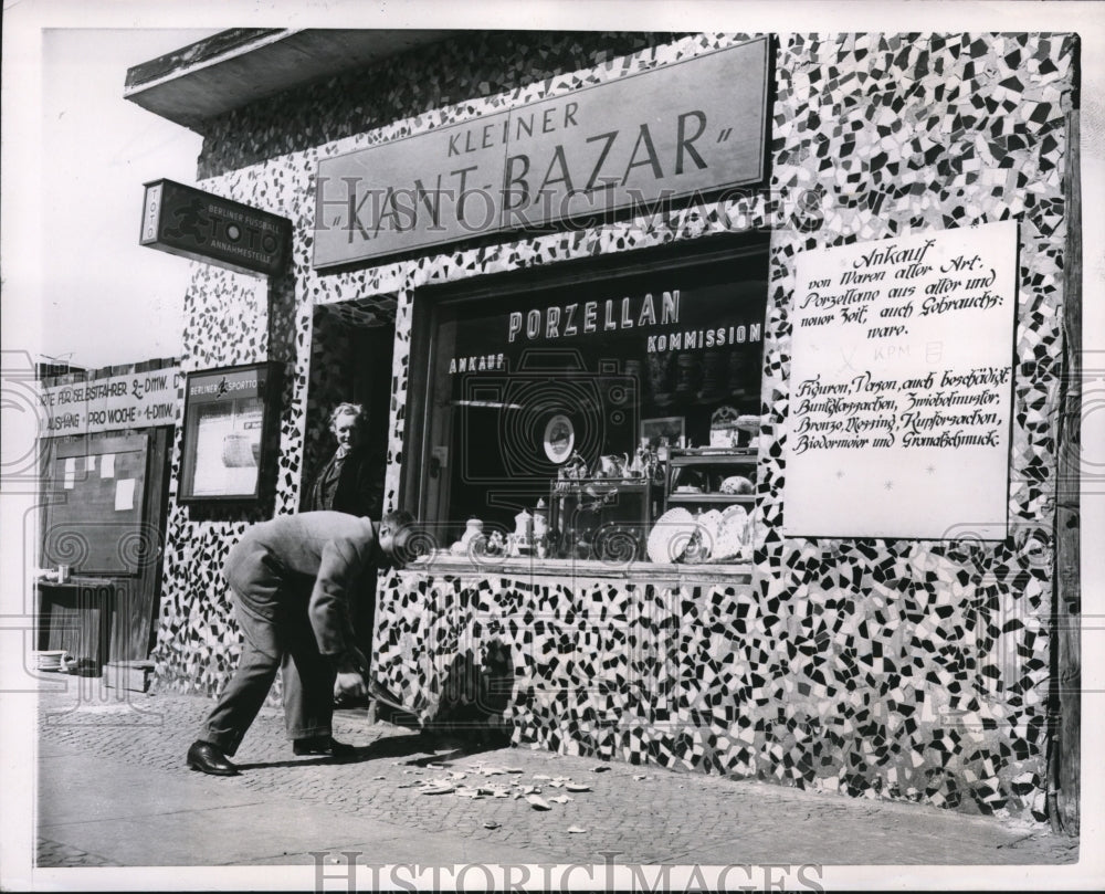 1953 Press Photo A West Berlin porcelain dealer brightens his shop with colors - Historic Images