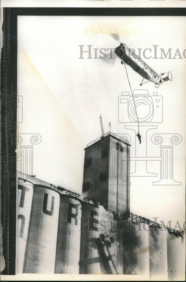 1960 Press Photo Badly burned Phillip Reeves dangles from rope with re ...