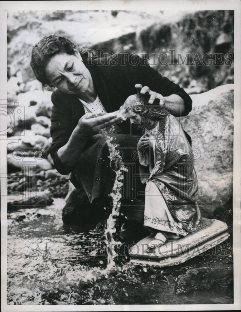 1958 Press Photo Woman Cleans Statue of Christ Swept by Flood in Alvan - Historic Images