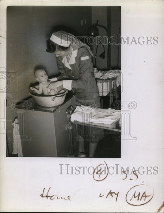1942 Press Photo of of nun bathing a baby. - Historic Images