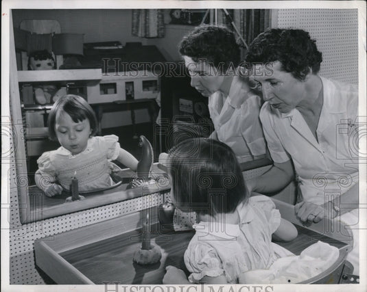 1955 Press Photo Ann Semanco blowing a candle with therapist Mrs. Richard Kreles-Historic Images