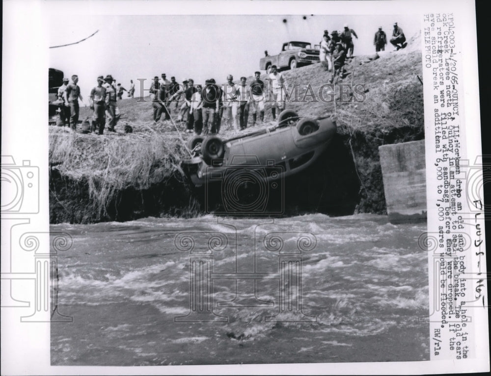 1965 Press Photo Quincy Ill workmen drop old auto into Rock Creek to seal leak-Historic Images