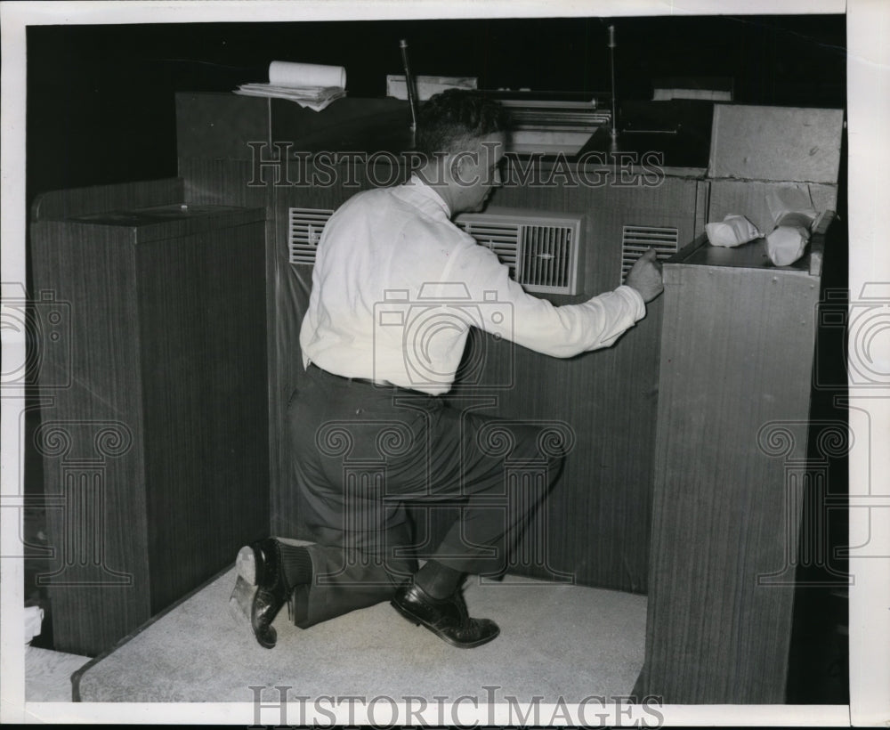 1956 Press Photo Ted Boidumeau examines air conditioning vent on restrum - Historic Images