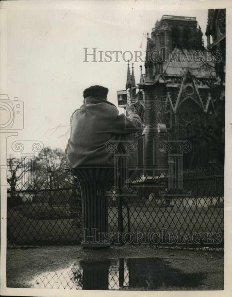 1957 Press Photo Tourist Admires the Beauty of Notre Dame Cathedral on Pedestal-Historic Images