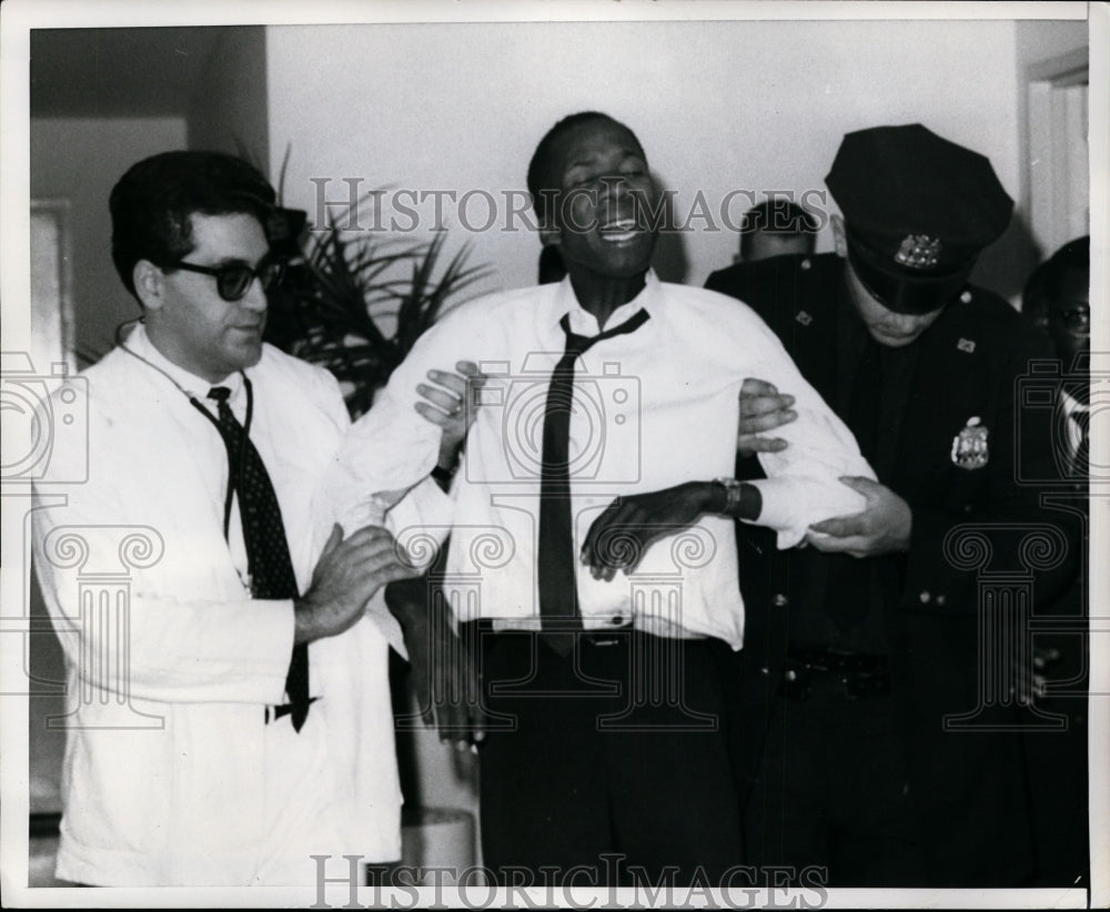 1966 Press Photo G.T. Mwalilino aided by a doctor and a policeman after hearing - Historic Images