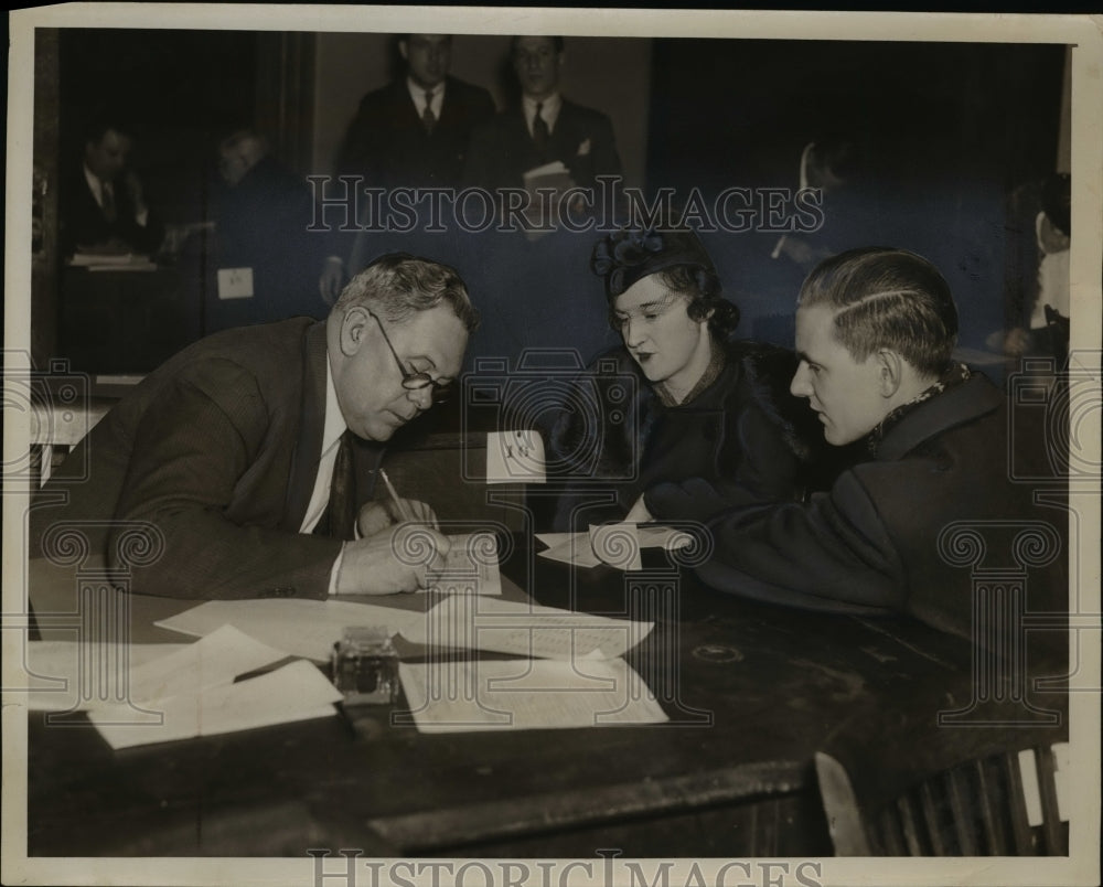 1943 Press Photo PJ Anderson Deputy Collector Helping Mr and Mrs Schnieder - Historic Images