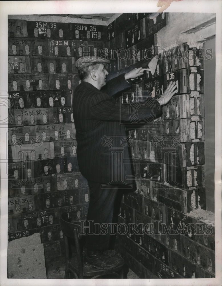 1951 Home builder putting finishing touches to wall of his cottage - Historic Images