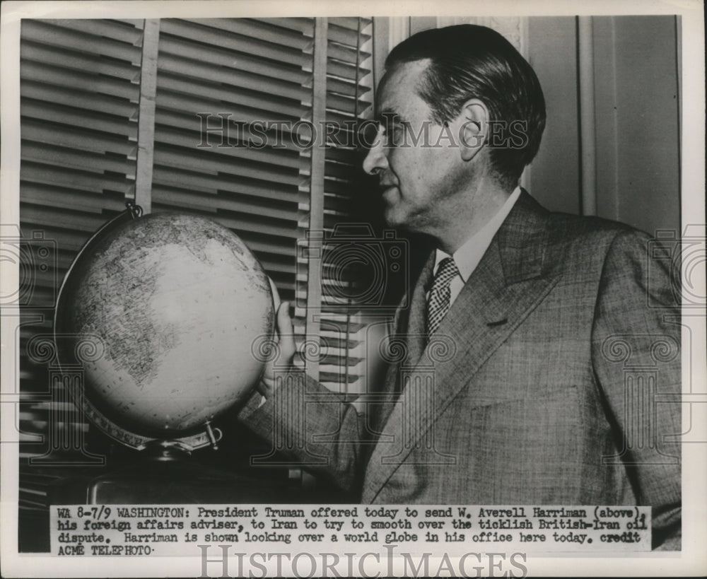 1951 Press Photo W. Averell Harriman looking over a world globe in his office - Historic Images