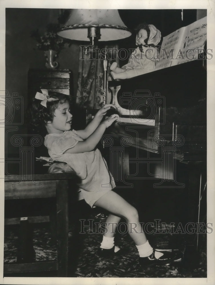 1945 Diane Graden braces herself against piano bench to reach pedal - Historic Images