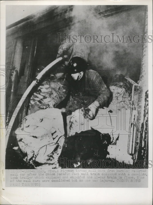 1952 Fireman throws mail bags from burning railroad mail car - Historic Images