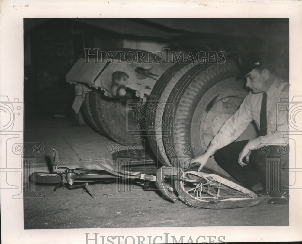 1955 A officer examines a bicycle  at scene of an accident - Historic Images