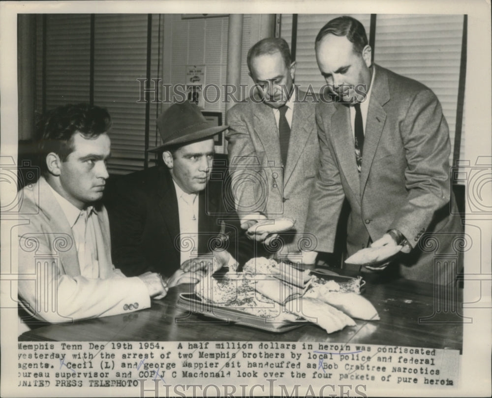 1954 Press Photo 2 Memphis sitted as the officers looks over the pure heroin-Historic Images