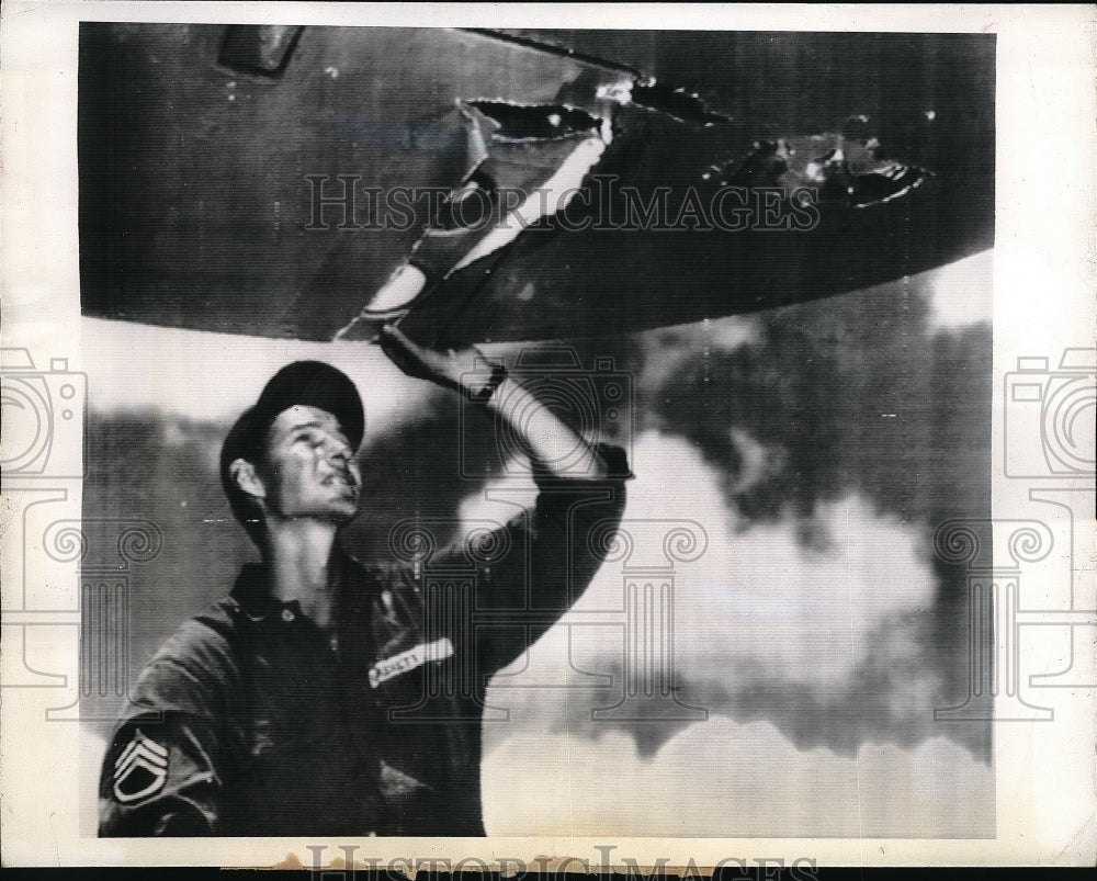 1942 Crewmen Sgt.Barnett examined damaged wing of Flying Fortress. - Historic Images