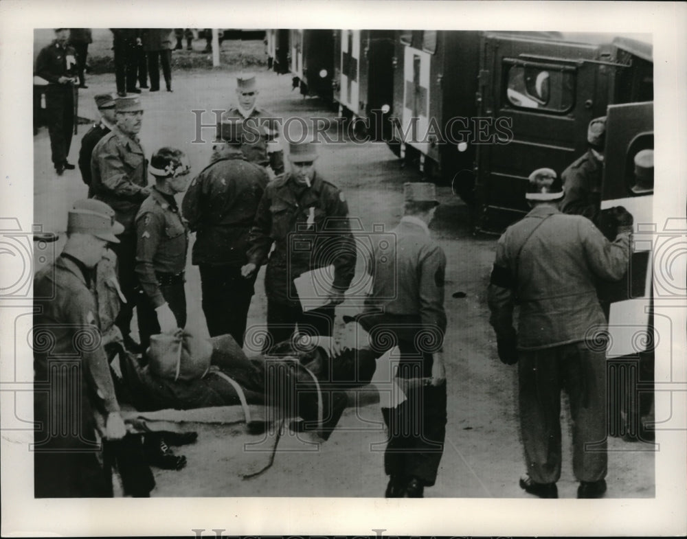 1953 Allied POW is carried to the waiting doors of an ambulance bus - Historic Images