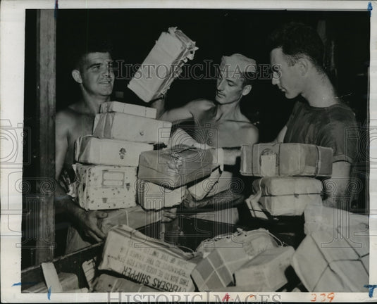 1944 United States Marines carry Christmas packages from mail truck - Historic Images