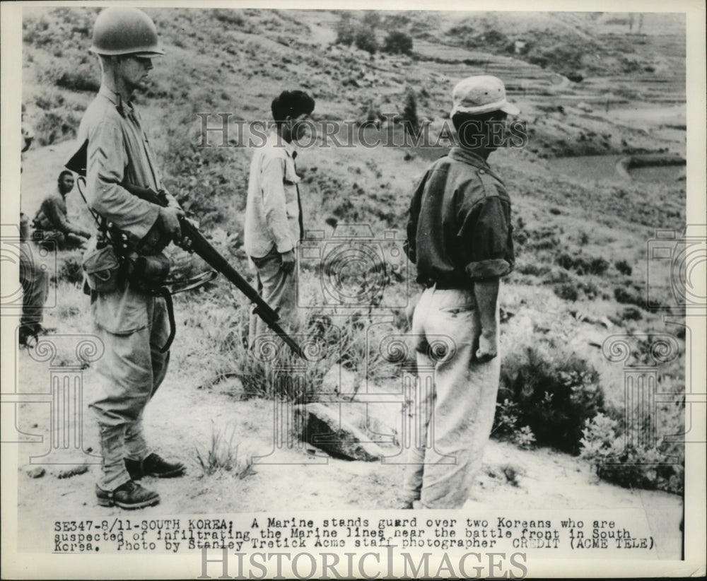 Press Photo Marine stands guard over two Koreans who crossed Marine lines - Historic Images