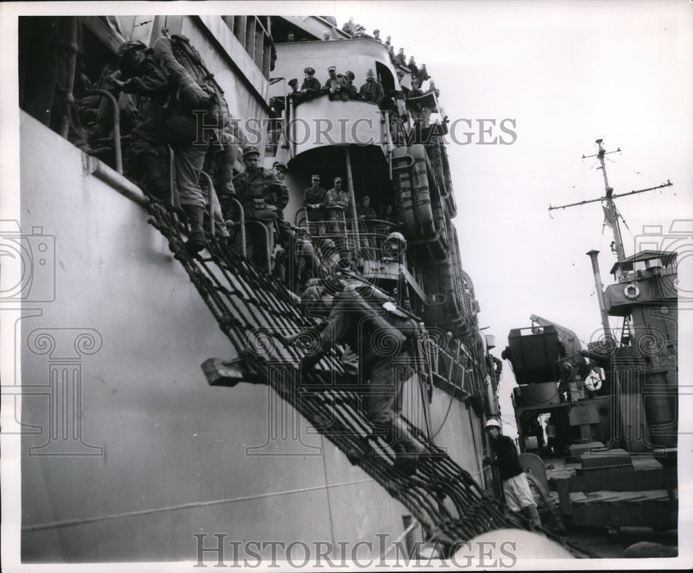 1951 United States Marine climbs landing net to a Landing Ship Tank - Historic Images