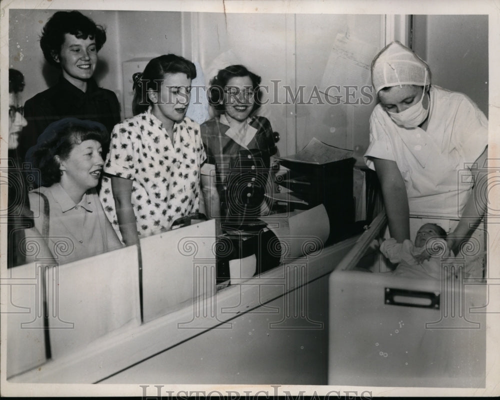 1952 nurse Catherine Dietrich shows newborn to ladies  - Historic Images