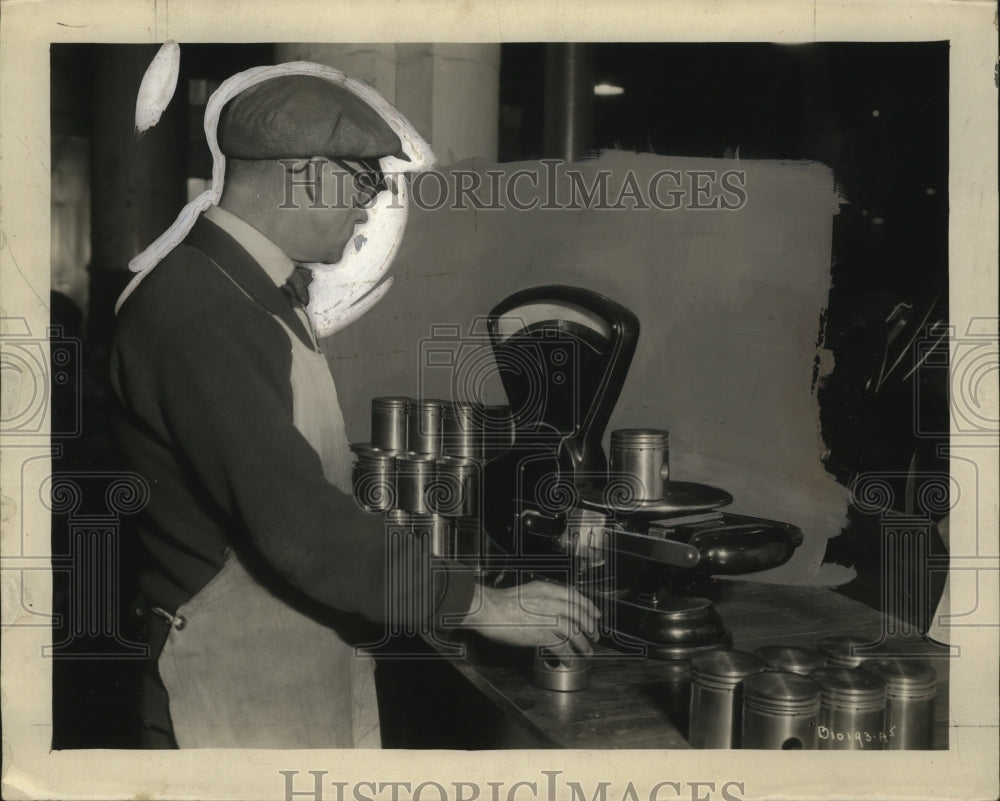 1937 Auto Manufacturer checks balance of pistons by weight - Historic Images