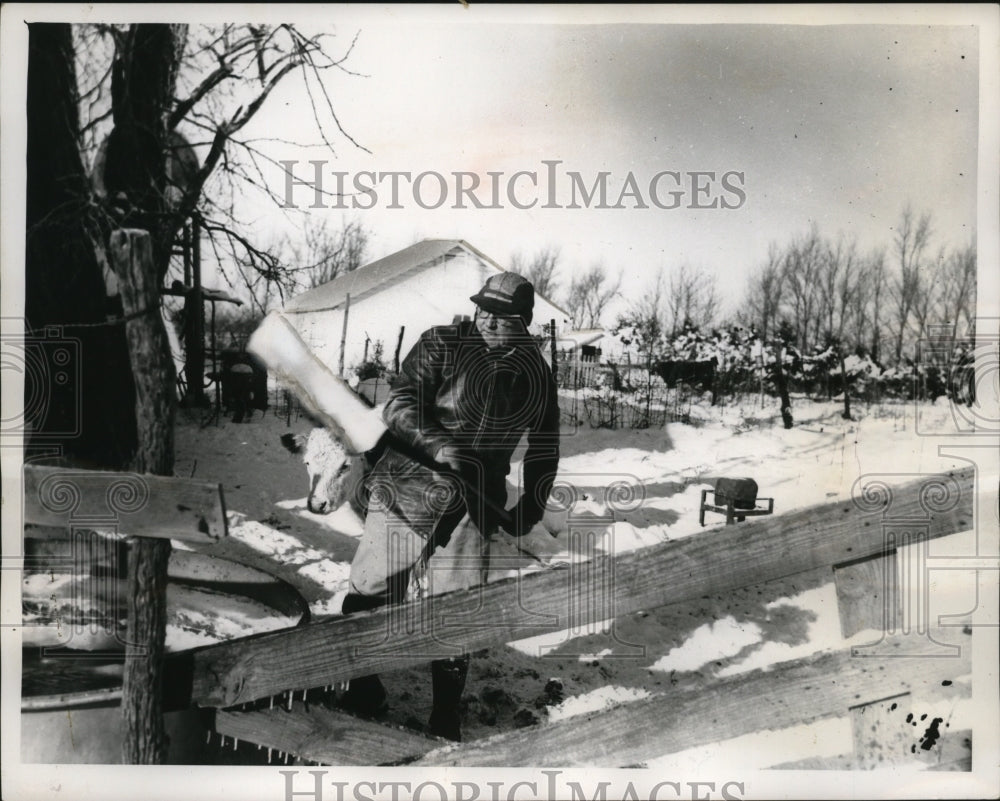 1962 Press Photo Lenoard Peters of Inman KS knocks ice from livestock water tank - Historic Images