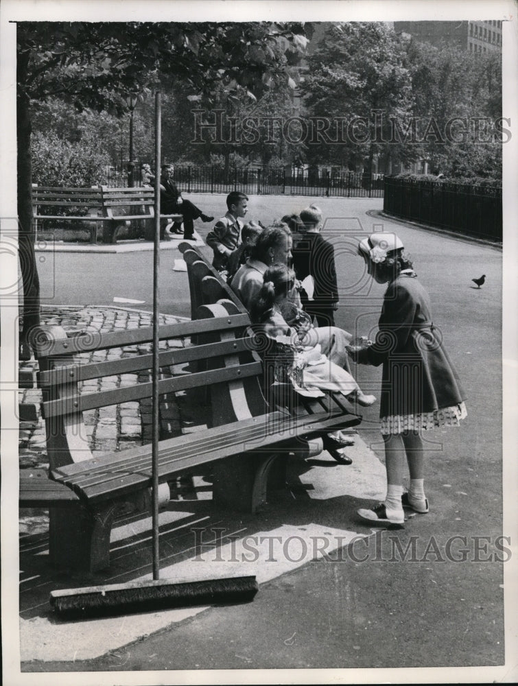 1957 Press Photo Broom sits on bench with picnickers in new York&#39;s Battery Park - Historic Images