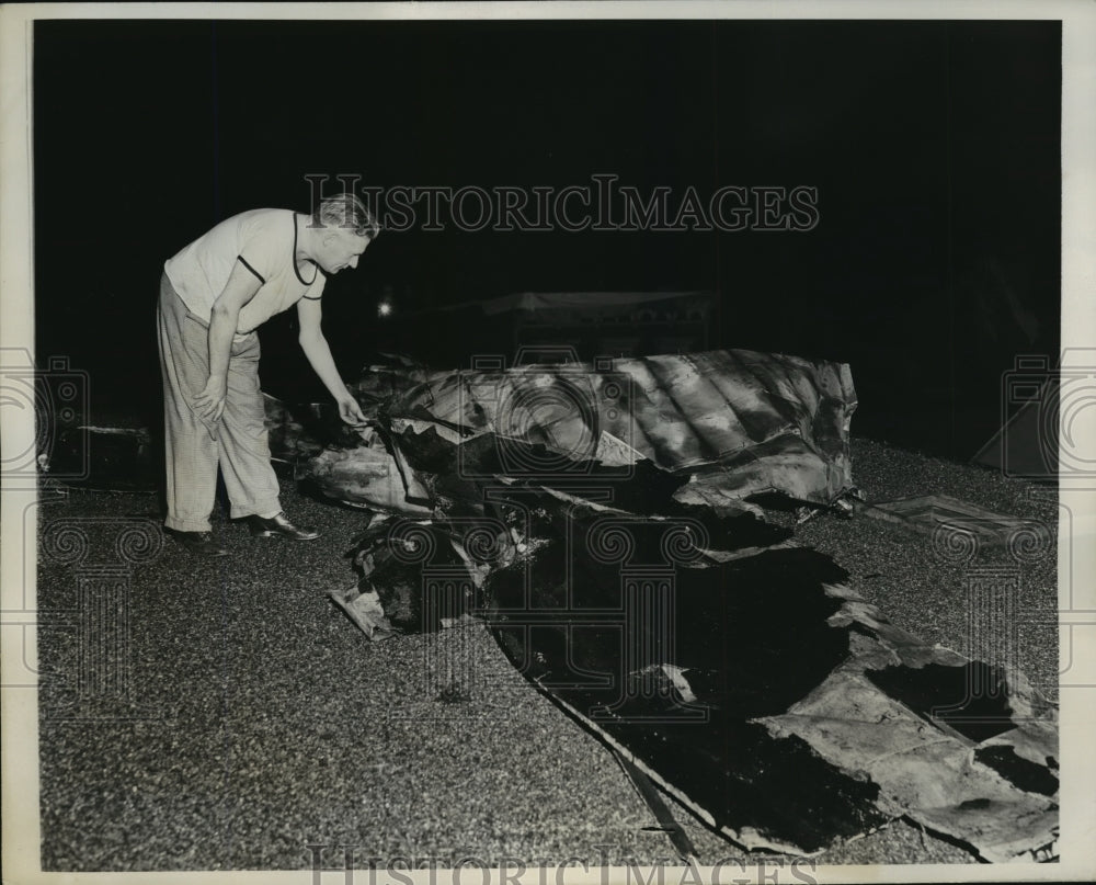 1940 Press Photo Newark J Hill stands on his roof inspecting damage - nera08853 - Historic Images