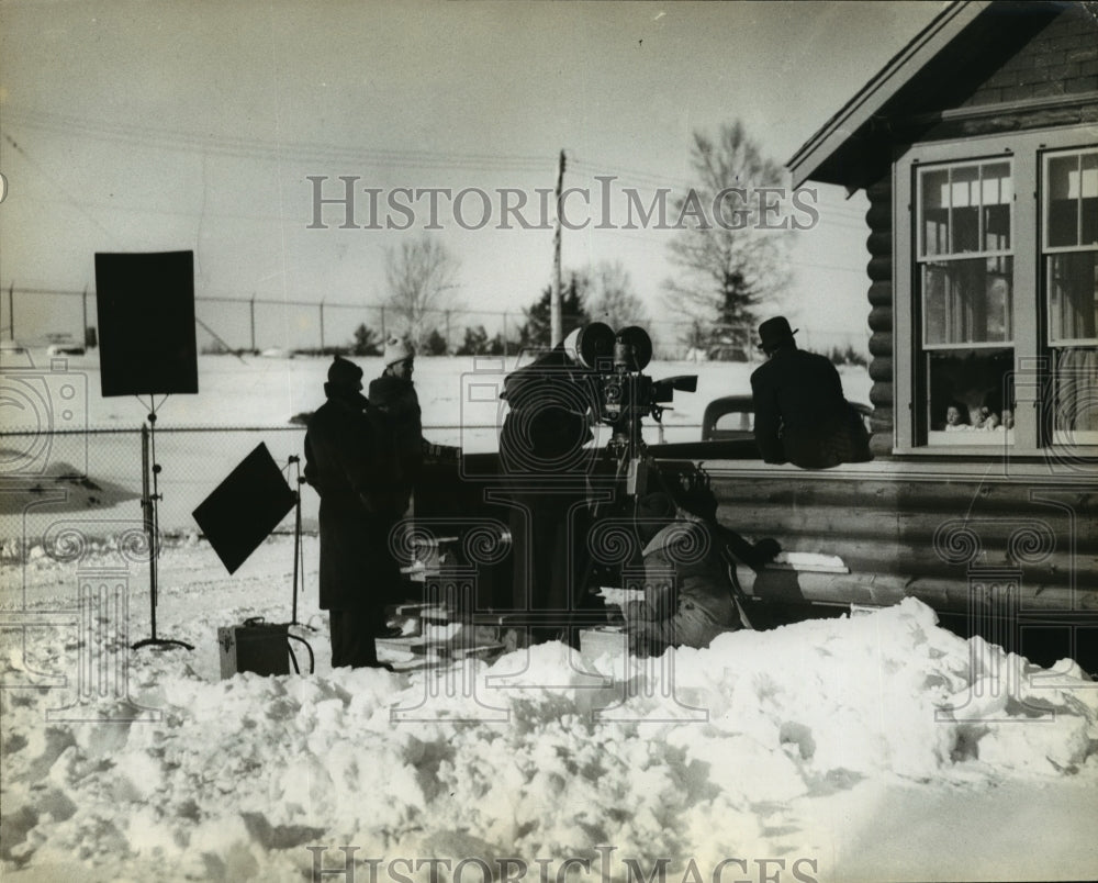 1936 Press Photo Film crew works on scene while quins watch from window - Historic Images