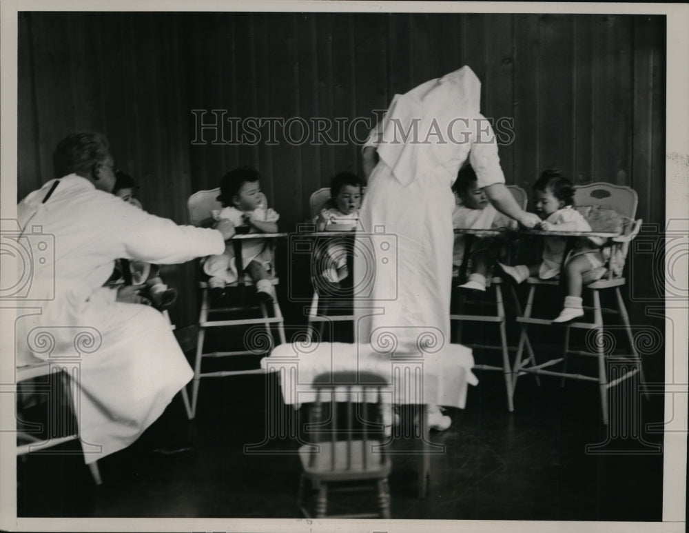 1936 Press Photo Dionne quintuplets fed their dinner by Jean Hersholt - Historic Images