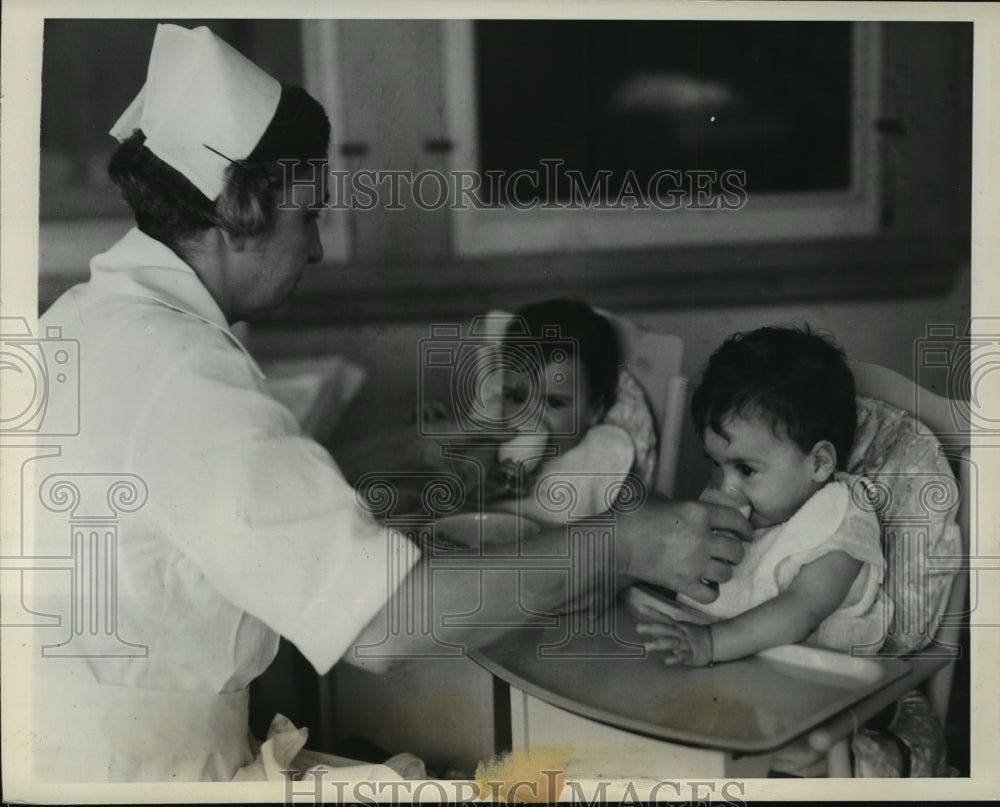 1935 Press Photo Nurse Lamoreux feeds Cecile and Emilie their dessert - Historic Images