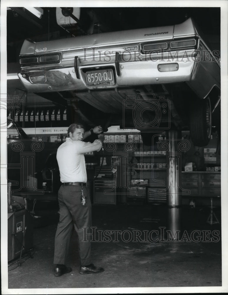 Auto attendant works on a car  - Historic Images