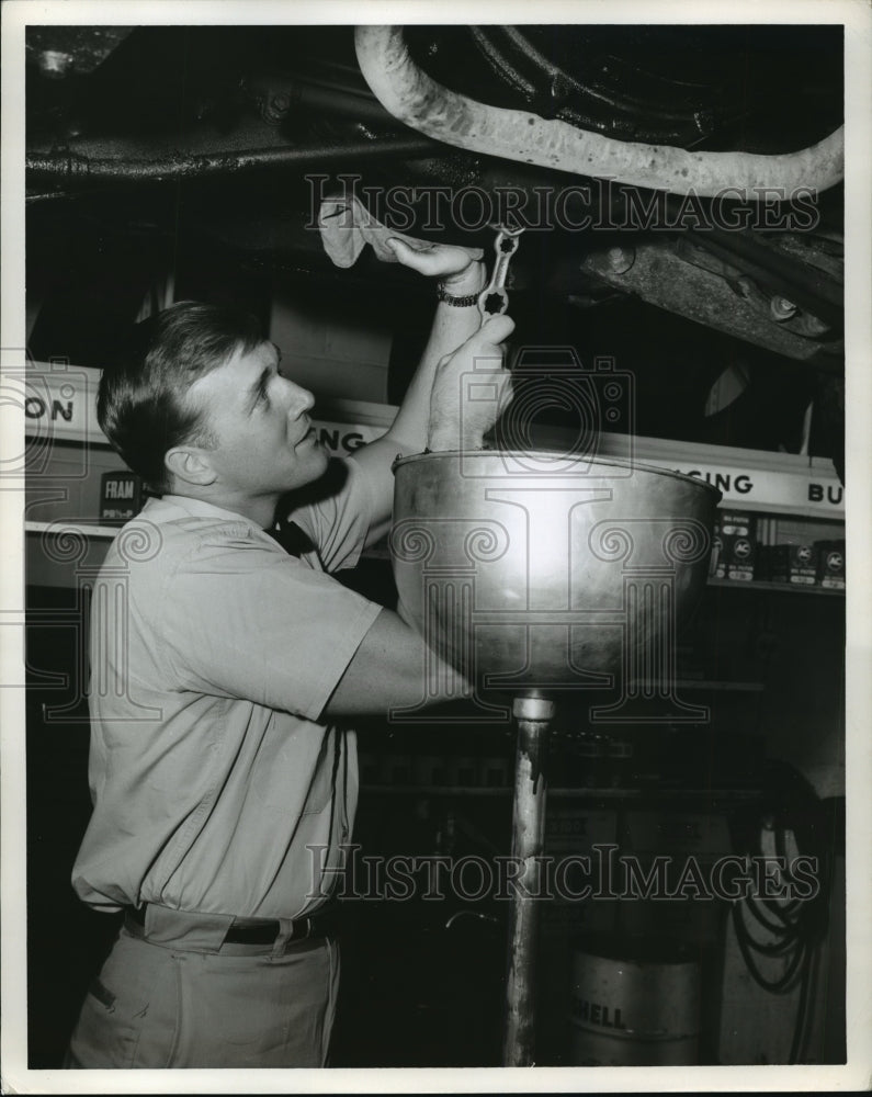 Press Photo Auto attendant changes oil in a car, by Ewing Galloway - nera12155 - Historic Images