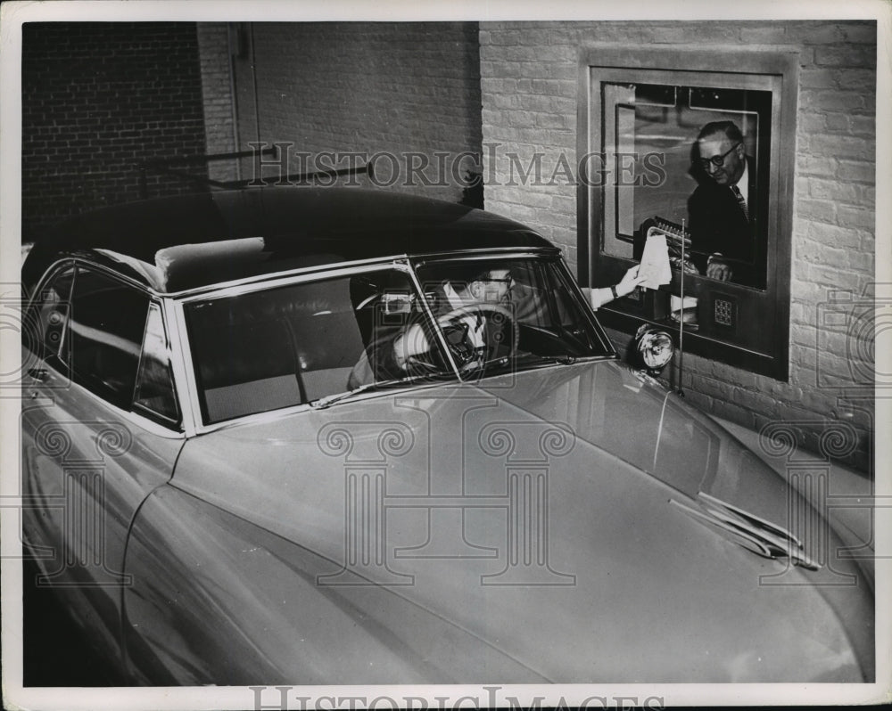 New York Driver conducts transaction in drive through of bank - Historic Images