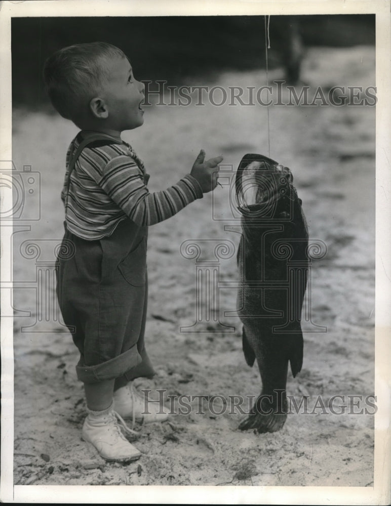 1944 Press Photo Don Dabney Looks In Awe At Big Mouth Bass Father Caught - Historic Images