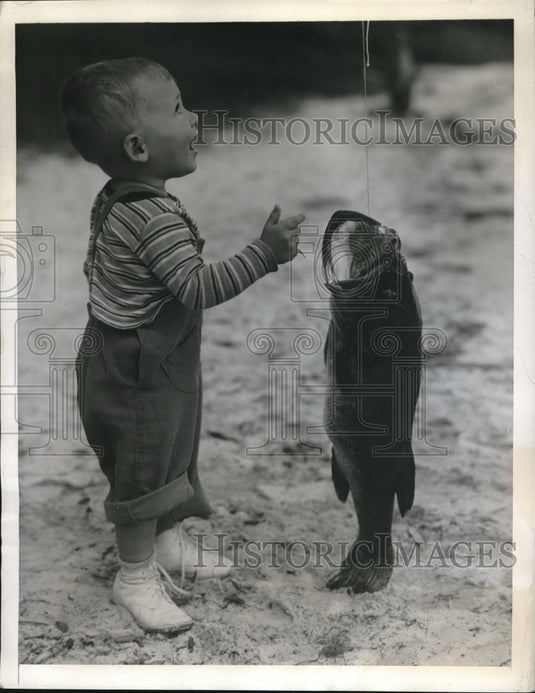1944 Press Photo Don Dabney Looks In Awe At Big Mouth Bass Father Caught - Historic Images