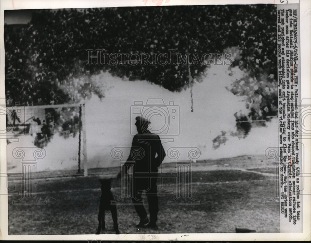 1964 Press Photo A Policeman with his dog as police lob tear gas - nes23778 - Historic Images