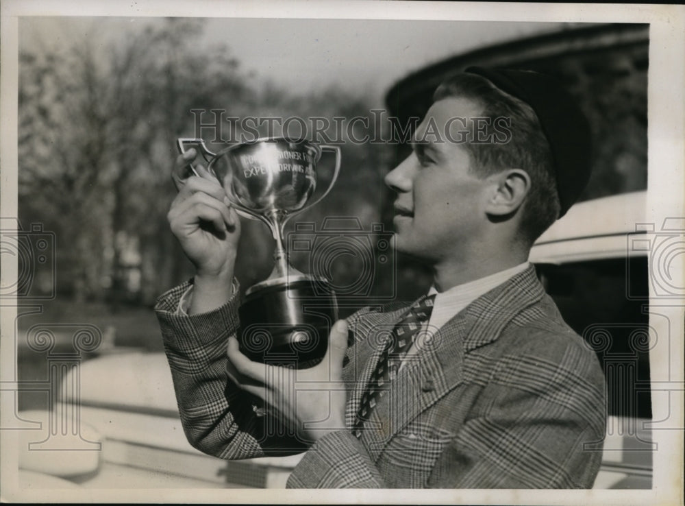 1938 Press Photo Elias Baker admires trophy he won for fastest reaction time - Historic Images