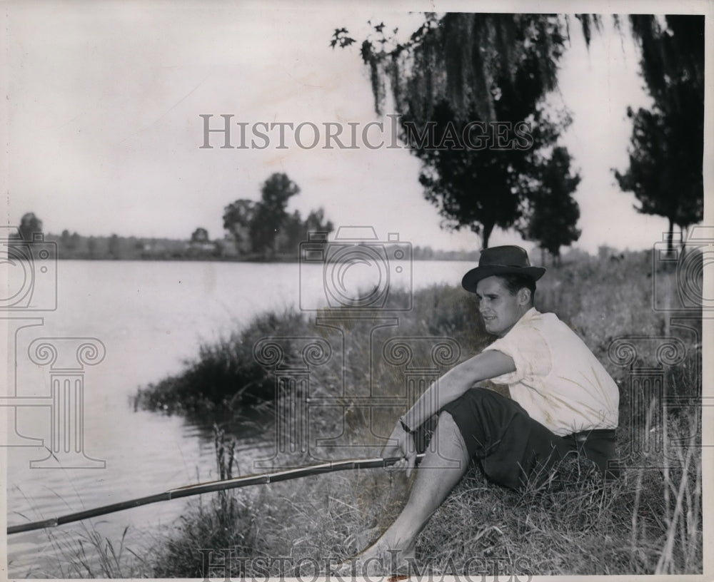 1939 Press Photo Ken Kavanaugh sitting on riverbank fishing - nes38474 - Historic Images