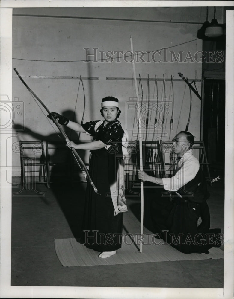 1940 Press Photo Father kneels down while daughter shoots a bow and arrow - Historic Images