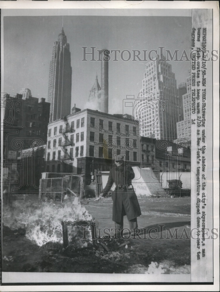 1958 Press Photo Man Burns Fish Crates To Keep Warm - Historic Images