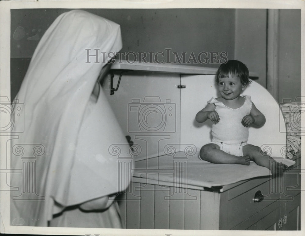 1935 Press Photo A baby & a nun at St Ann's hospital - Historic Images
