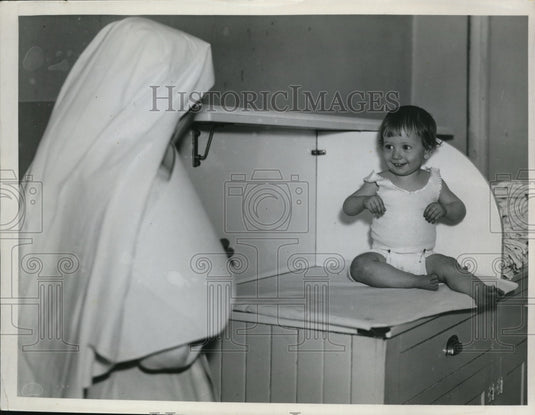 1935 Press Photo A baby & a nun at St Ann's hospital - Historic Images