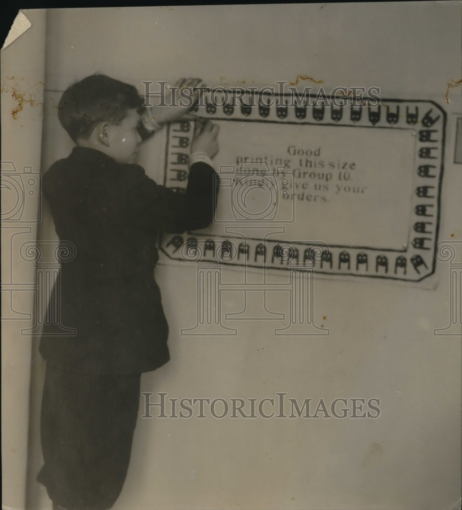 1922 Press Photo Out for business for his class John is shown putting up ad for - Historic Images