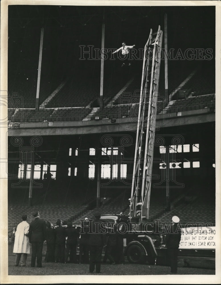 1941 Press Photo Firemen with ladder truck  to get man out of bleachers - Historic Images