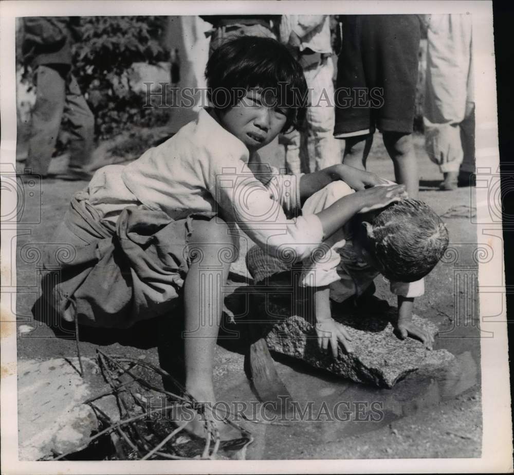 1952 Big sister washes a little girl&#39;s hair near Seoul Korea-Historic Images