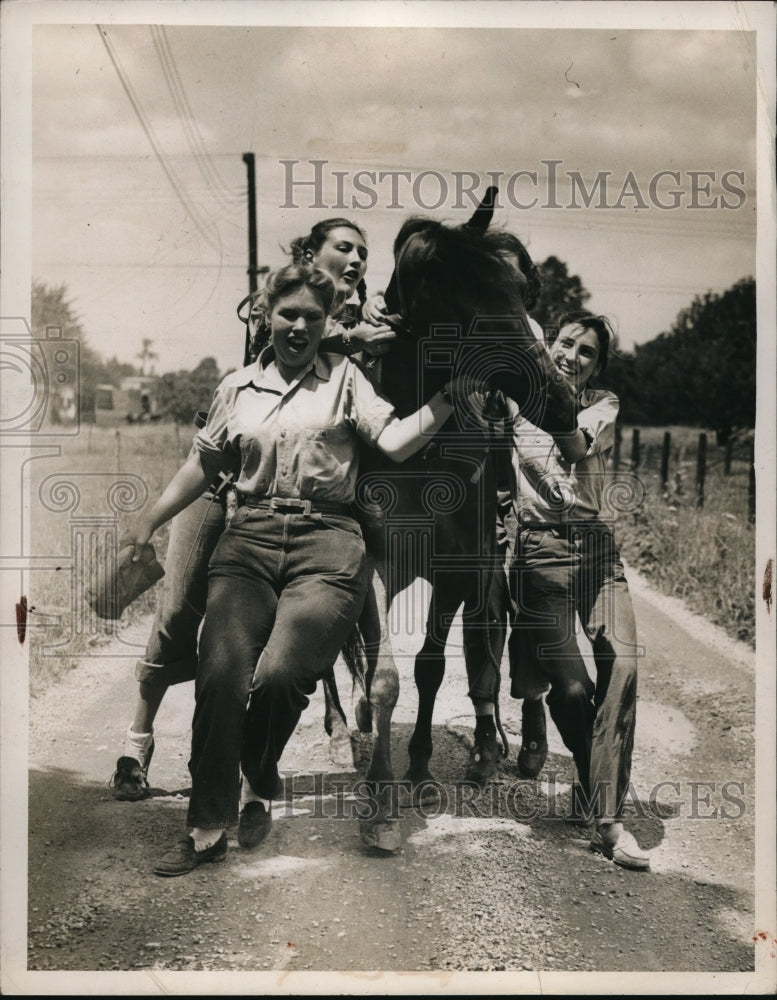 1947 Press Photo Carole Hinslee, tries to mount Towny with friend&#39;s help - Historic Images